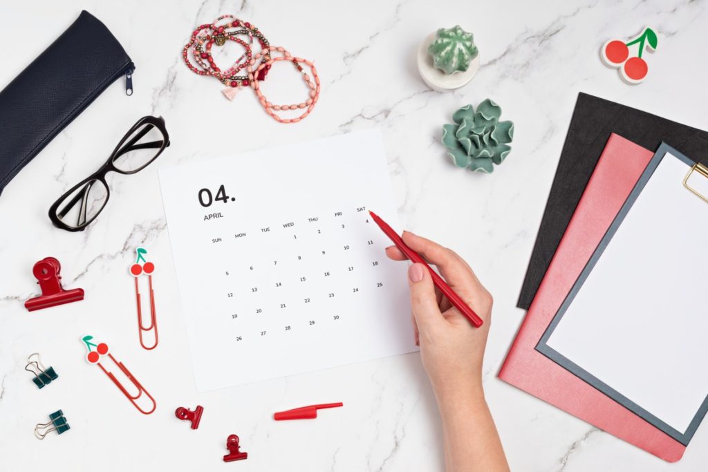 Desktop with calendar for april and office supplies